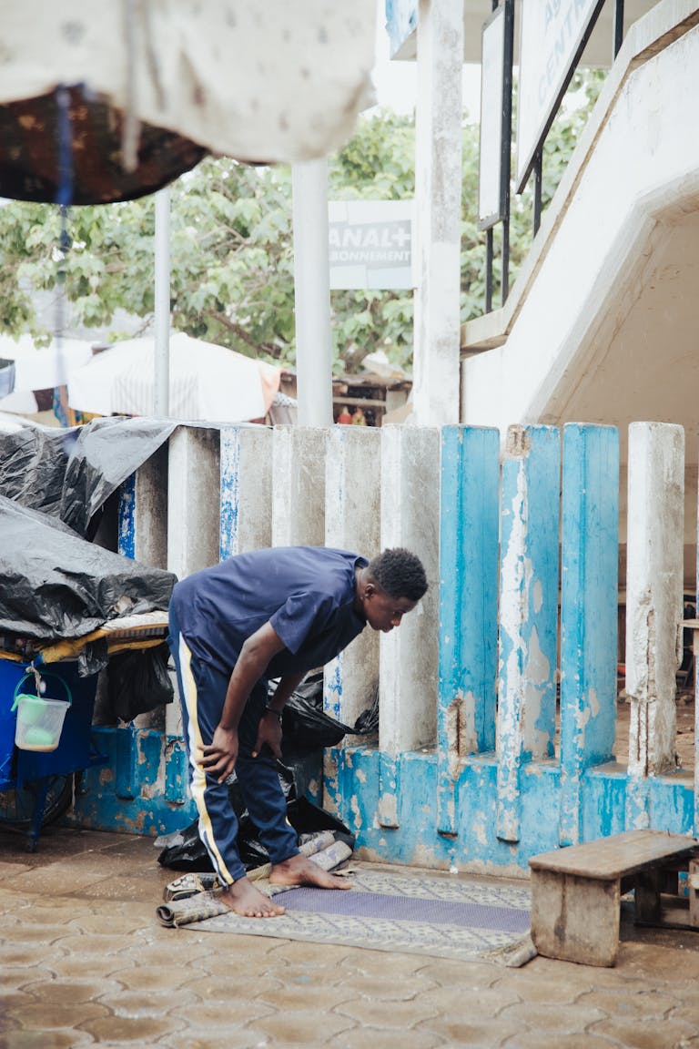 A man is cleaning the sidewalk with a broom