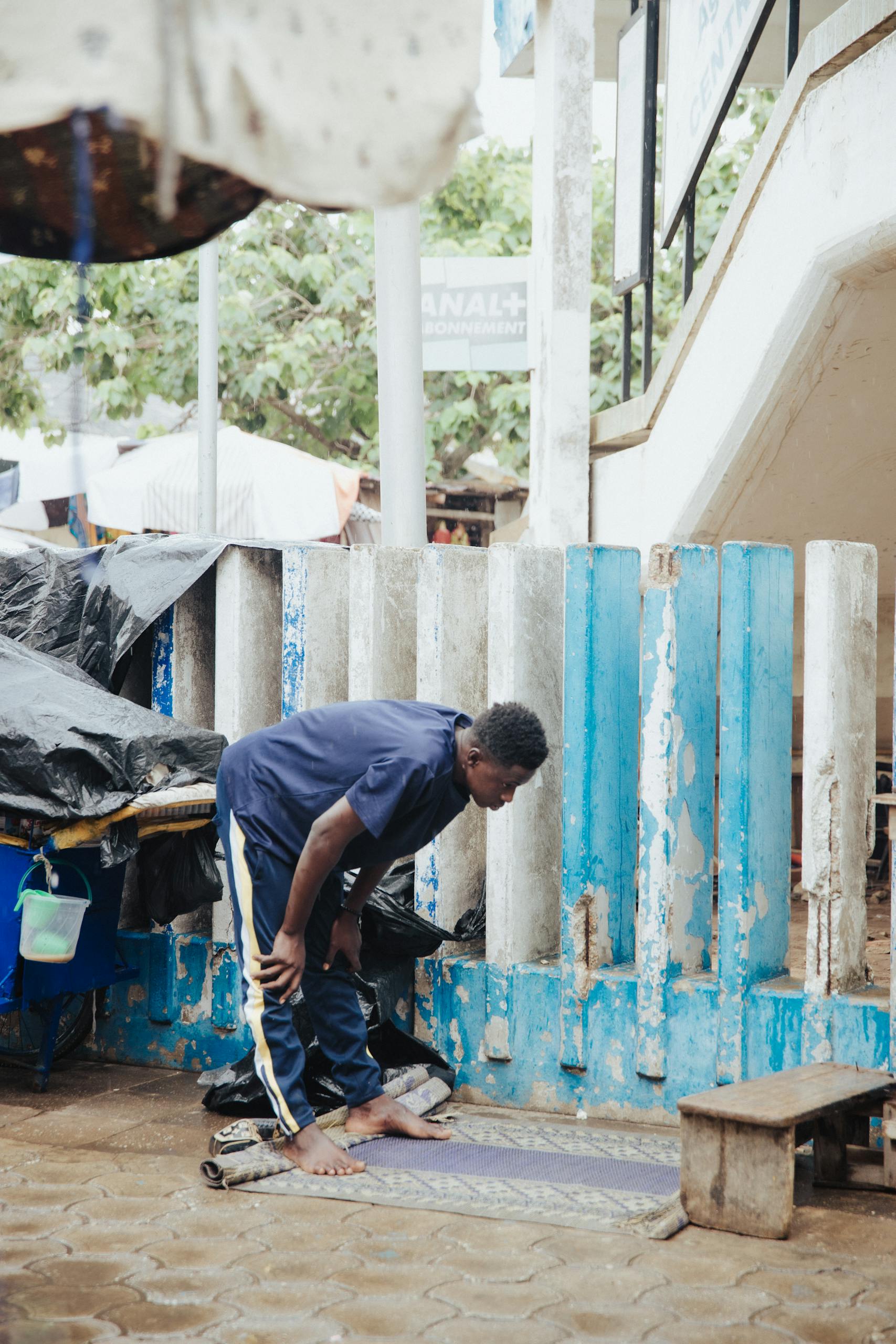 A man is cleaning the sidewalk with a broom
