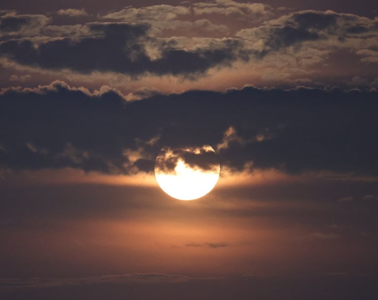 Light Moon Behind Clouds in the Evening
